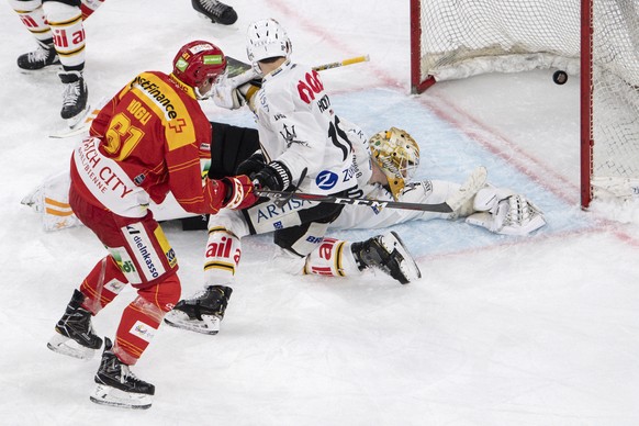 Biels Michael Huegli, links, trifft gegen Luganos Torhueter Elvis Merzlikins zum 1:3 im Eishockey Meisterschaftsspiel der National League zwischen dem EHC Biel und dem HC Lugano, am Dienstag, 22. Janu ...