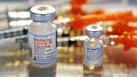 FILE - In this Feb. 25, 2021, file photo, vials for the Moderna and Pfizer COVID-19 vaccines are displayed on a tray at a clinic set up by the New Hampshire National Guard in the parking lot of Exeter ...