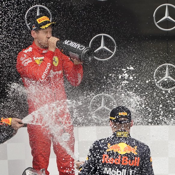 epa07746040 Dutch Formula One driver Max Verstappen (R) of Aston Martin Red Bull Racing and German Formula One driver Sebastian Vettel of Scuderia Ferrari, celebrate at the winning ceremony at the 201 ...