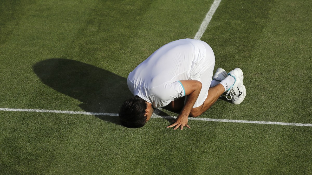 Marcos Baghdatis of Cyprus kisses the court after after losing to Italy's Matteo Berrettini in a Men's singles match during day four of the Wimbledon Tennis Championships in London, Thursday ...