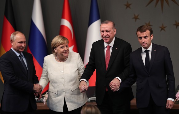 epa07124776 Turkish President Recep Tayyip Erdogan (2-R), German Chancellor Angela Merkel (L), French President Emmanuel Macron (R), and Russian President Vladimir Putin (2-L) attend a press conferenc ...