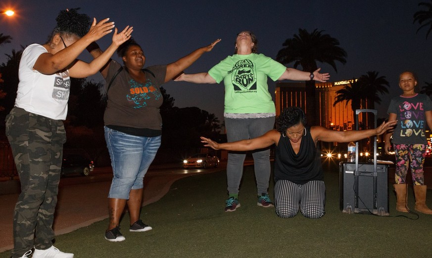 epa06243333 Parishioners from The Gathering church pray near the Mandalay Bay hotel in memory of the victims of the mass shooting in Las Vegas, Nevada, USA, 03 October 2017. Police reports indicate th ...