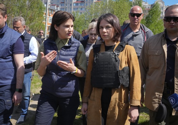 German Foreign Minister Annalena Baerbock, right, and Ukrainian Prosecutor General Iryna Venediktova talk as they stand near a mass grave in Bucha, on the outskirts of Kyiv, Ukraine, Tuesday, May 10,  ...