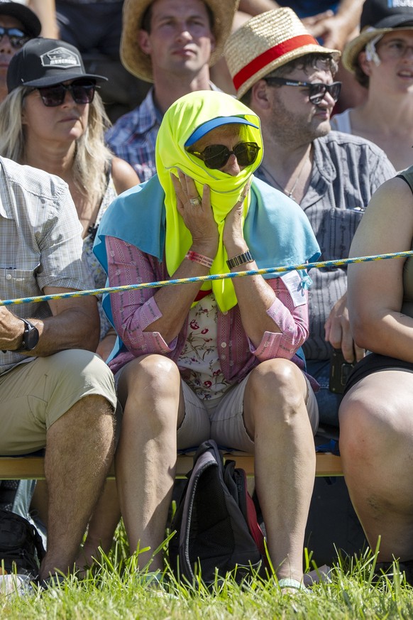 Eine Frau schuetzt sich vor der Sonne im dritten Gang am Schwarzseeschwinget, am Sonntag, 21. Juni 2026, in Schwarzsee. (KEYSTONE/Peter Schneider)