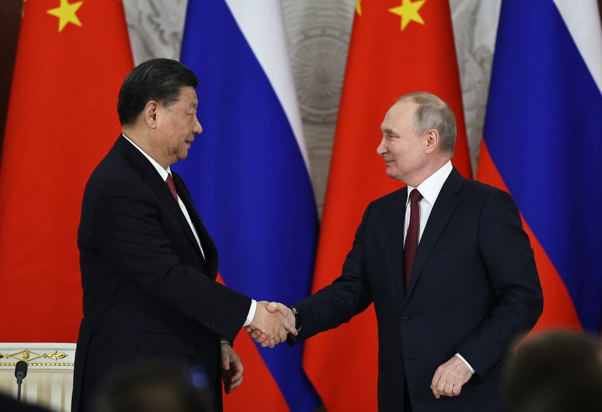epa10535406 Chinese President Xi Jinping (L) and Russian President Vladimir Putin (R) shake hands during the signing ceremony of documents concerning the further development and cooperation between Ru ...