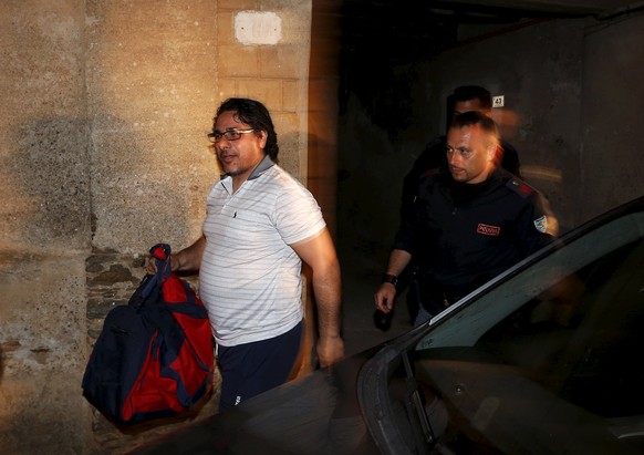 A man identified as Pino Fazio (L) is escorted by Italian policemen after being detained during Operation Columbus in Pianopoli village, near Catanzaro, Italy May 7, 2015. Italian and U.S. agents brok ...