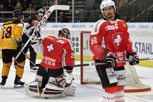 Switzerland’s goalkeeper Rober Mayer, left, and his teamate Eric Blum, right, react after the scoring to 1:1 during the Ice Hockey Deutschland Cup at the Curt-Frenzel-Eisstadion in Augsburg, Germany,  ...