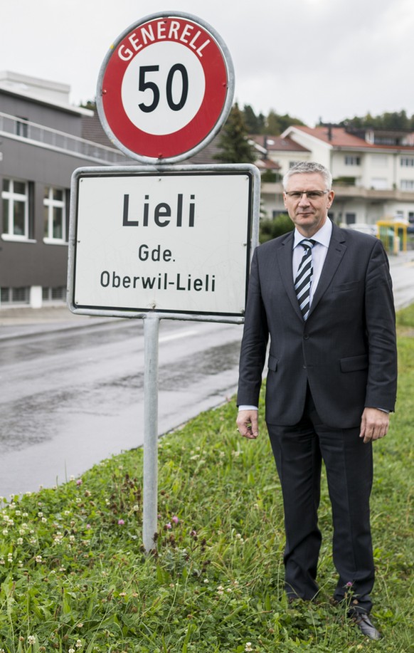 Andreas Glarner, Gemeindeammann Oberwil-Lieli, posiert eingangs Dorf Lieli vor der Ortstafel in Oberwil-Lieli, Kanton Aargau, am Mittwoch, 23. September 2015. Im Hintergrund links das Gebaeude seines  ...