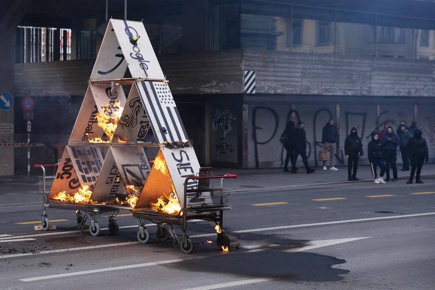 epa07300662 Protesters burn down a house of cards during a demonstration against the World Economic Forum (WEF) in Bern, Switzerland, 19 January 2019. The WEF will take place from 22 -25 January 2019  ...