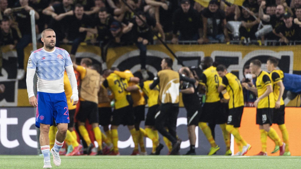 epa09468541 Manchester's Luke Shaw (L) shows his dejection while YB's players celebrate the winning goal in overtime during the UEFA Champions League group F soccer match between BSC Young B ...