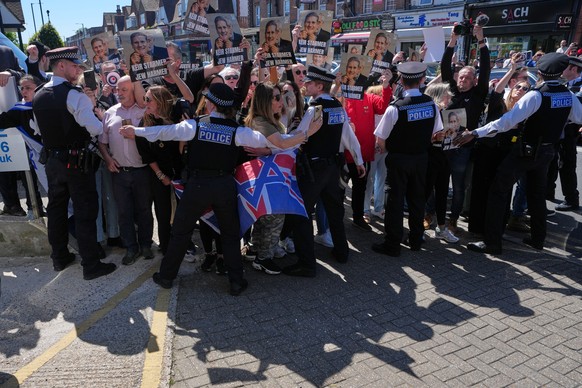 Protesters hold posters near the scene where two people were stabbed yesterday in the Golders Green neighbourhood, that has a large Jewish community, in London, Thursday, April 30, 2026.(AP Photo/Alas ...