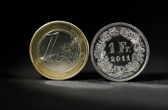 ARCHIVBILD - EURO UEBERSCHREITET ZUM ERSTEN MAL SEIT JANUAR 2015 DIE MARKE VON 1,15 FRANKEN - A coin of 1 Euro (left) and a coin of 1 Swiss Franc (right), pictured on July 21, 2011.(KEYSTONE/Martin Ru ...