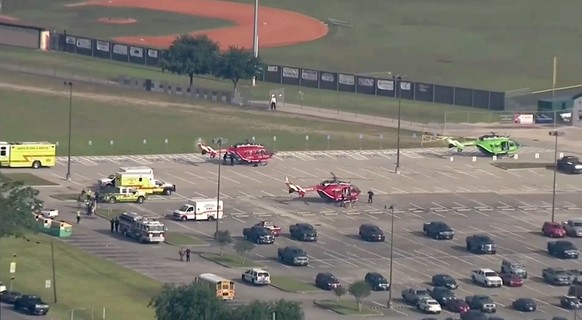 In this image taken from video helicopters sit in the parking lot of Santa Fe High School as law enforcement officers respond to the school near Houston after an active shooter was reported on campus, ...