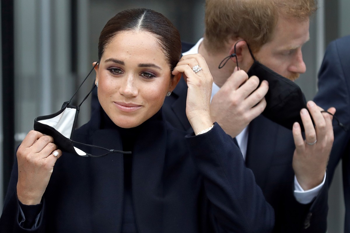 epa09620994 YEARENDER 2021 FACES OF THE YEAR..Britain's Meghan, Duchess of Sussex (L) and Prince Harry, Duke of Sussex remove their protective face masks before posing for photographers in front  ...