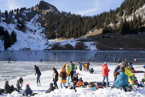 People enjoy ice skating on the black ice of the Hinterstockensee, on Saturday, December 17, 2016, above Erlenbach in the Simmental valley, Canton of Bern, Switzerland. (KEYSTONE/Anthony Anex)