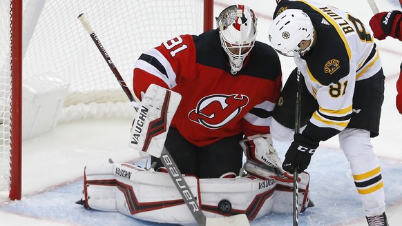 New Jersey Devils goaltender Gilles Senn (31) makes a save against Boston Bruins left wing Anton Blidh (81) during the third period of an NHL preseason hockey game, Monday, Sept. 16, 2019, in Newark,  ...