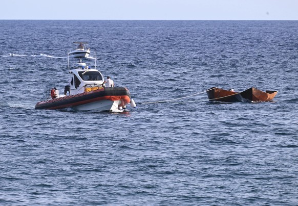 epa10868147 Crew members of an Italian Coast Guard boat tow two small boats in which migrants were rescued at sea, off the coast of Lampedusa, Italy, 18 September 2023. More than 1,000 migrants remain ...