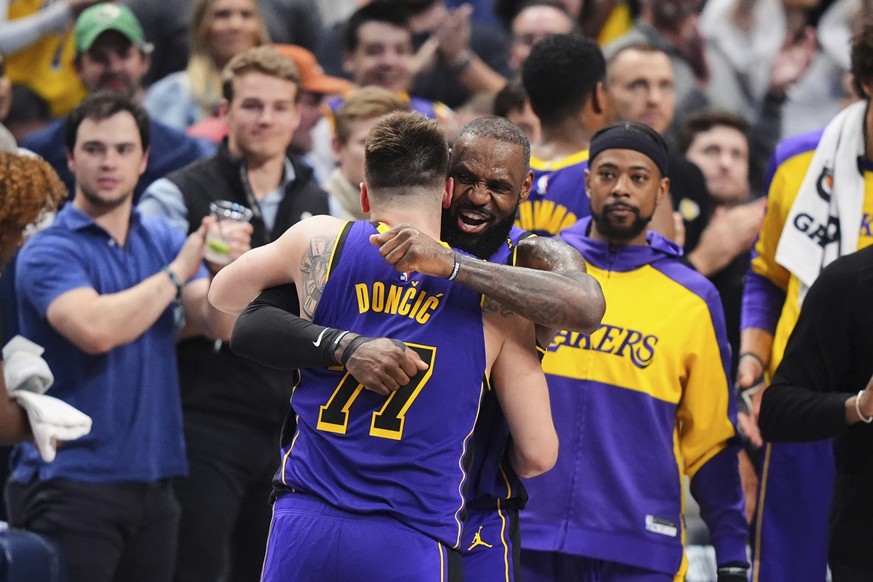 Los Angeles Lakers&#039; Luka Doncic (77) and LeBron James, center, right, hug and celebrate late in the second half of an NBA basketball game against the Dallas Mavericks in Dallas, Wednesday, April  ...
