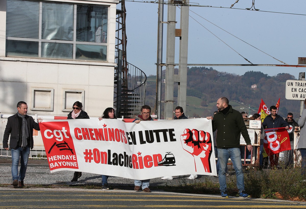 Rail workers of CGT union hold a banner that reads: "Railworkers in Struggle" as they demonstrate in Hendaye, southwestern France, Friday, Dec. 6, 2019. Frustrated travelers are meeting tran ...
