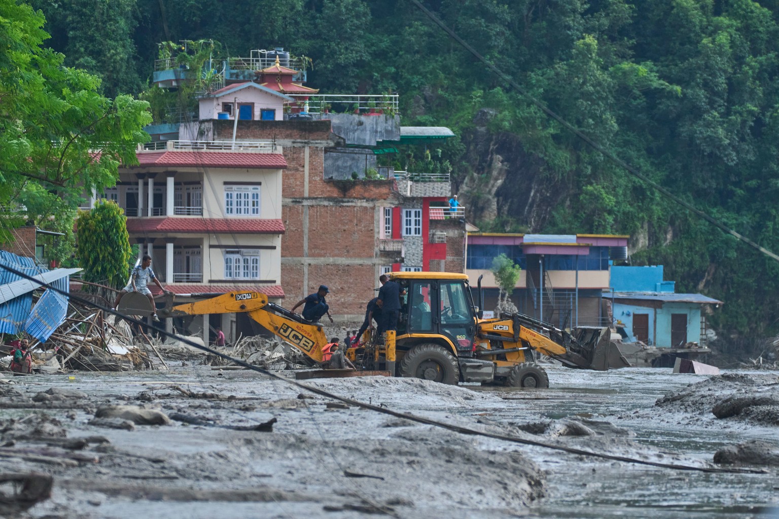 Rescuers use earthmovers to reach submerged houses after flash flooding along the Trishuli River in Nepal's Nuwakot district, Wednesday, Aug. 26, 2026. (AP Photo/Niranjan Shrestha)
Nepal Flash Fl ...