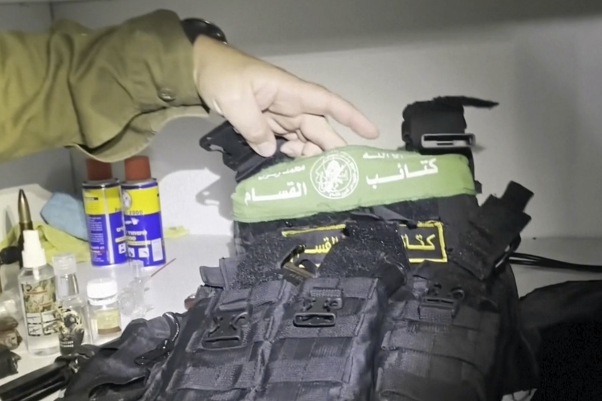 In this image taken from a video released by the Israeli Defense Forces, Wednesday, Nov. 15, 2023, Lt. Col. Jonathan Conricus, an Israeli military spokesman, holds up a bullet proof vest with a Hamas  ...