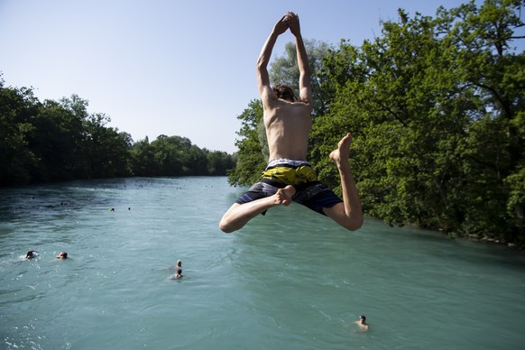 People jump from a bridge in the Aare River during the sunny and warm weather, in Bern. Switzerland, Wednesday, June 26, 2019. The forecasts predict hot weather in Switzerland with the maximum tempera ...