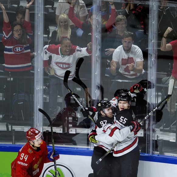 epa06744958 Colton Parayko (R) and Connor McDavid (C) of Canada celebrate the 1-0 lead during the IIHF World Championship quarter final ice hockey match between Russia and Canada at Royal Arena in Cop ...