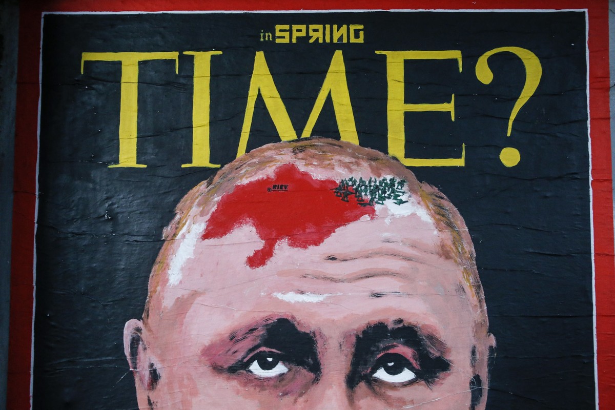 epaselect epa09763248 A man passes the street art work 'SpringTime' by street artist HarryGreb depicting a portrait of Russian president Putin on the cover of Time magazine, in a street in R ...