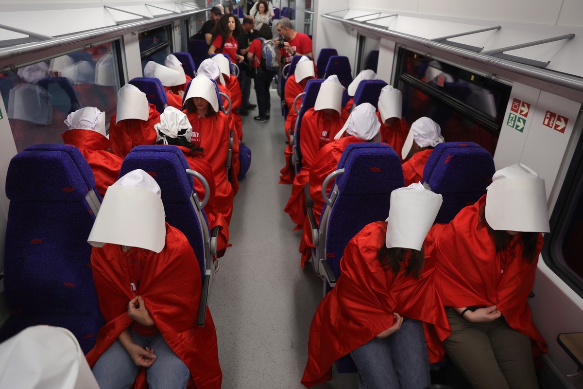 epa10496485 Women wearing costumes from the TV series 'The Handmaid's Tale' ride a train during an anti-government protest in Jerusalem, Israel, 01 March 2023. People have been protesti ...