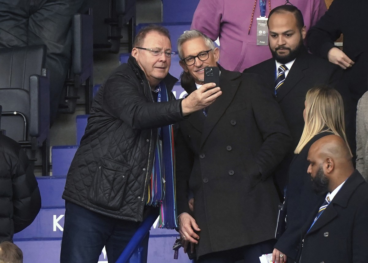 Soccer broadcaster Gary Lineker, centre right, poses for photographs with a fan in the stands, ahead of the English Premier League soccer match between Leicester City and Chelsea at the King Power Sta ...