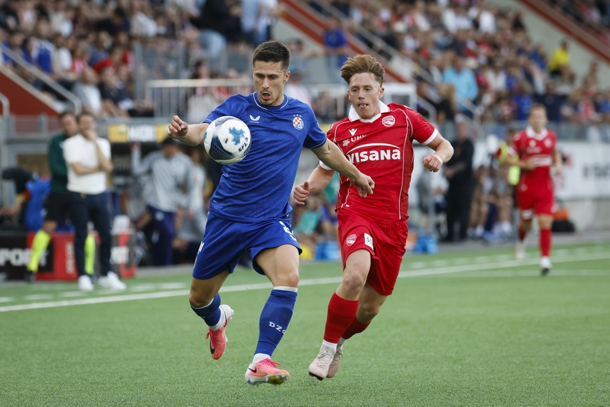 epa13125285 Zagreb's Mateo Lisica (L) and Thun's Michael Heule in action during the UEFA Champions League second qualifying round match between FC Thun and Dinamo Zagreb, in Thun, Switzerlan ...