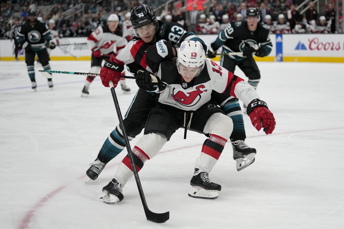 New Jersey Devils center Nico Hischier (13) skates toward the puck in front of San Jose Sharks defenseman Nikita Okhotiuk (83) during the second period of an NHL hockey game in San Jose, Calif., Tuesd ...