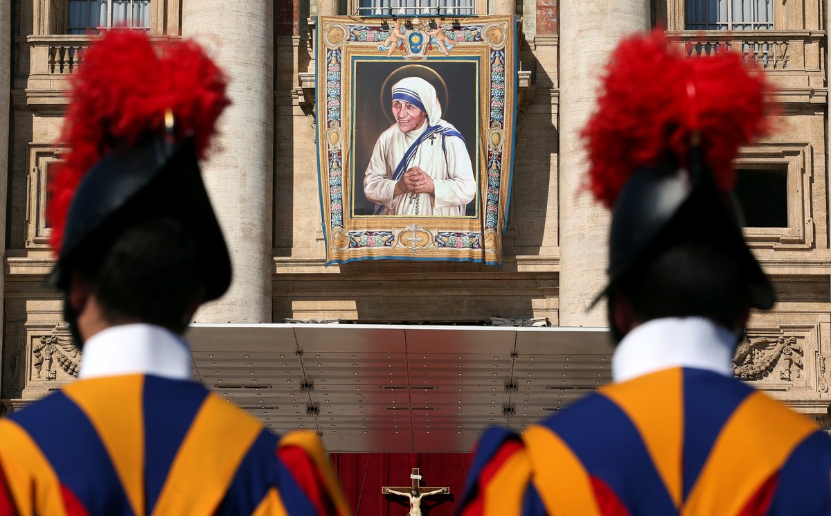Swiss Guards stand in front of a tapestry depicting Mother Teresa of Calcutta before a mass, celebrated by Pope Francis, for her canonisation in Saint Peter's Square at the Vatican September 4, 2 ...