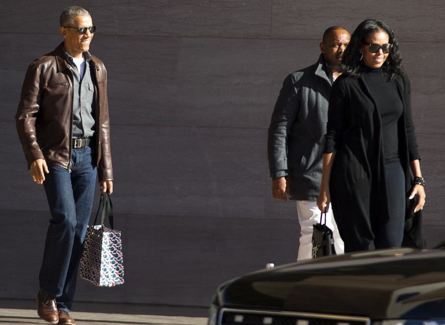 Former President Barack Obama accompanied by former first lady Michelle Obama leaves the National Gallery of Art in Washington, Sunday, March 5, 2017. President Trump has accused former President Bara ...