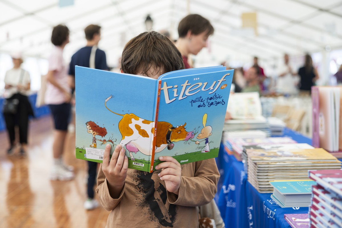 Nathan regarde la bande dessinee "Titeuf, petite poesie des saisons" de l'auteur Suisse Zep lors de la 16eme edition de la manifestation "Le Livre sur les Quais" ce dimanche,  ...