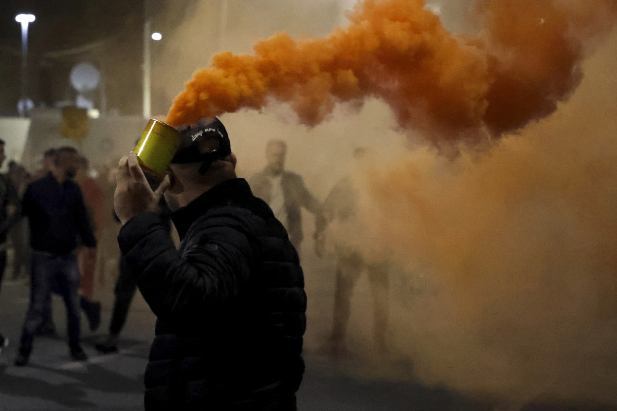 An opposition protester holds a flare during an anti-government rally set up by the opposition, in Tirana, Albania, Monday, Oct. 7, 2024. (AP Photo/Hameraldi Agolli)