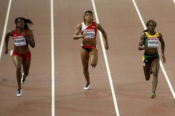 Elaine Thompson of Jamaica (R) runs to win ahead of Candyce McGrone of the U.S. (L) and Mujinga Kambundji of Switzerland (C) in their women&#039;s 200 metres semi-final during the 15th IAAF World Cham ...