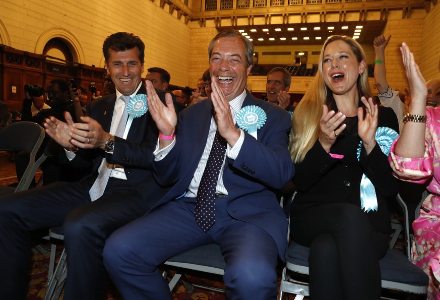 Brexit Party leader Nigel Farage, center, reacts as results are announced at the counting center for the European Elections for the South East England region, in Southampton, England, Sunday, May 26,  ...