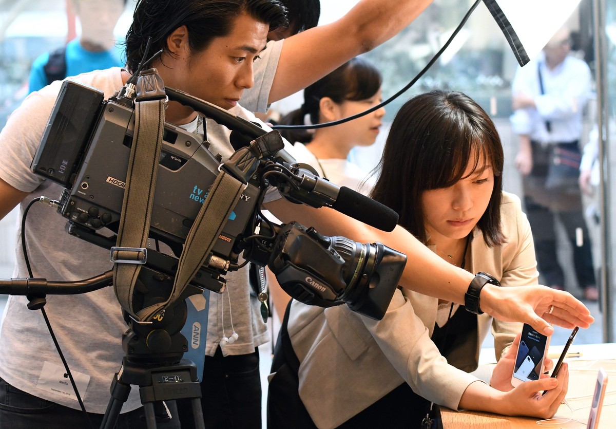 epa05541654 A TV crew films Apple's new iPhone 7 and iPhone 7 Plus at the Apple Store of Omotesando shopping district in Tokyo, Japan, 16 September 2016. Some Apple fans have been lining up for t ...