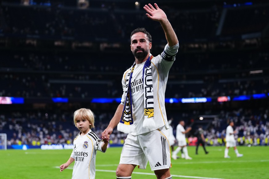 Real Madrid's Dani Carvajal ewalks ith his son during a farawell ceremony afyer his last macth for the club after a La Liga soccer match between Real Madrid and Athletic in Madrid, Spain, Saturda ...
