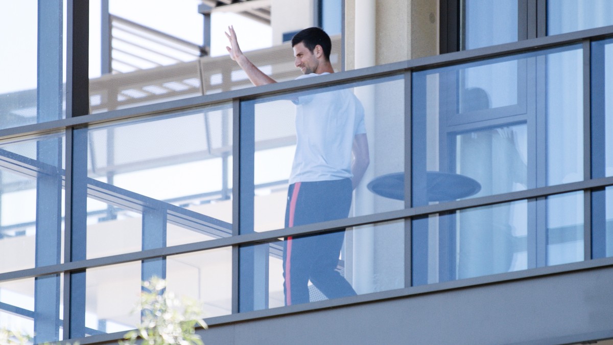 epa08947628 Novak Djokovic on the balcony of the M Suites accomodation, where some Australian Open competitors are currently under quarantine after testing positive for Covid-19, in North Adelaide, Au ...