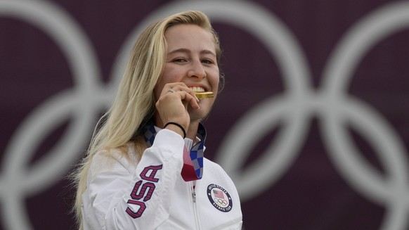 Nelly Korda, of the United States, bites her gold medal of the women&#039;s golf event at the 2020 Summer Olympics, Saturday, Aug. 7, 2021, at the Kasumigaseki Country Club in Kawagoe, Japan. (AP Phot ...