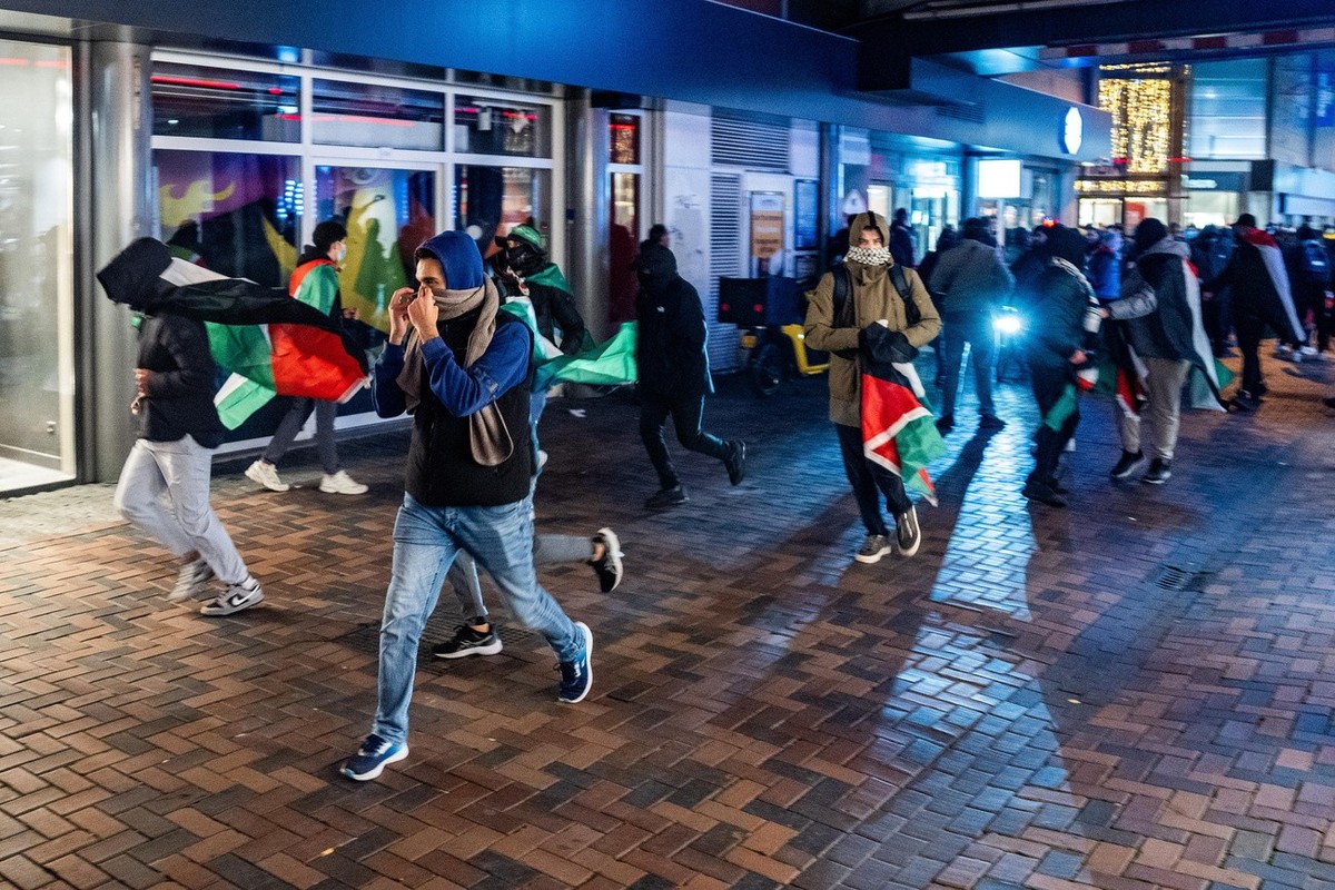 epa11708049 Demonstrators run with Palestinian flags ahead of the UEFA Europa League match between Ajax and Maccabi Tel Aviv at Anton de Komplein in Amsterdam, Netherlands, 07 November 2024. Originall ...
