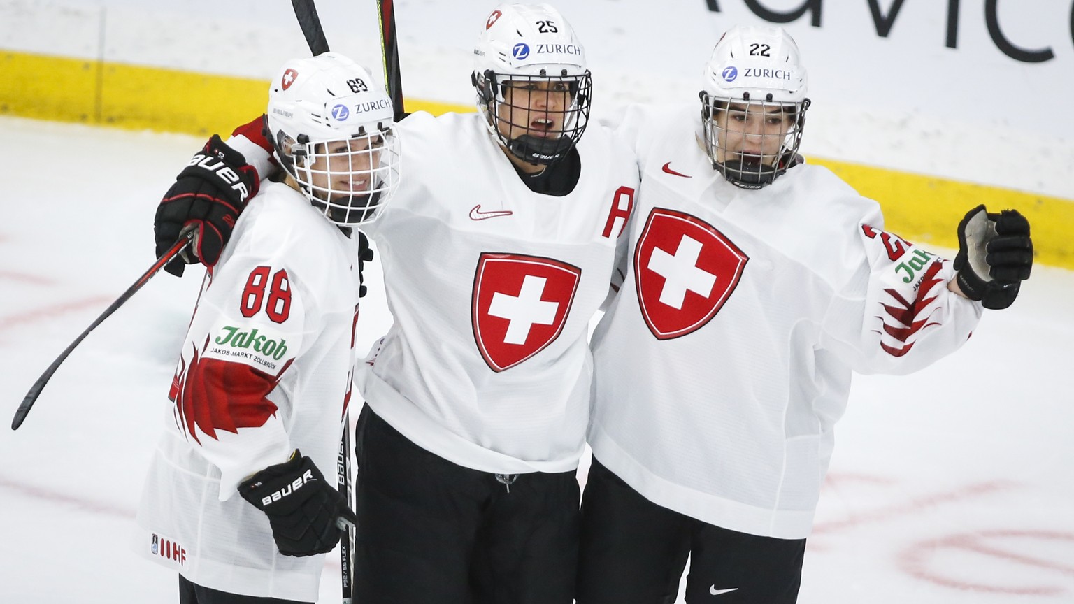Switzerland&#039;s Alina Muller, center, celebrates her goal against Russia with Sinja Leemann, right, and Phoebe Staenz during the first period of an IIHF women&#039;s hockey championships game in Ca ...