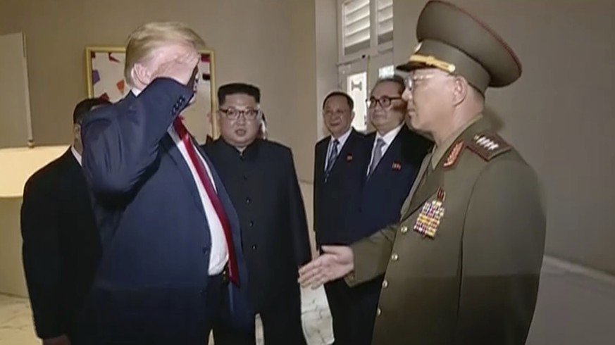 In this image made from June 12, 2018, video released by KRT, U.S. President Donald Trump salutes No Kwang Chol, minister of the People's Armed Forces of North Korea, as North Korean leader Kim J ...
