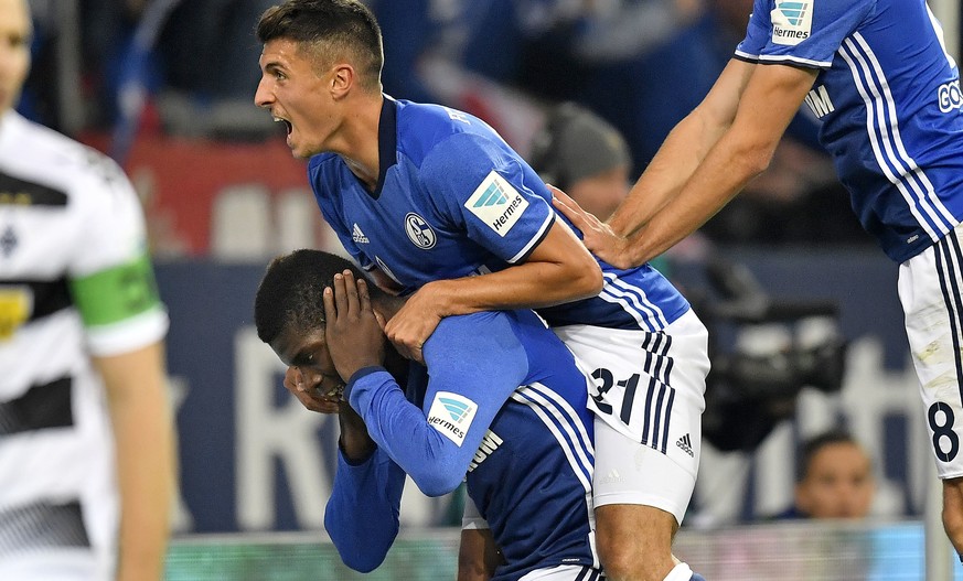 Schalke&#039;s Alessandro Schoepf jumps on scorer Breel Embolo, center, to celebrate their side&#039;s 2nd goal during the German Bundesliga soccer match between FC Schalke 04 and Borussia Moenchengla ...