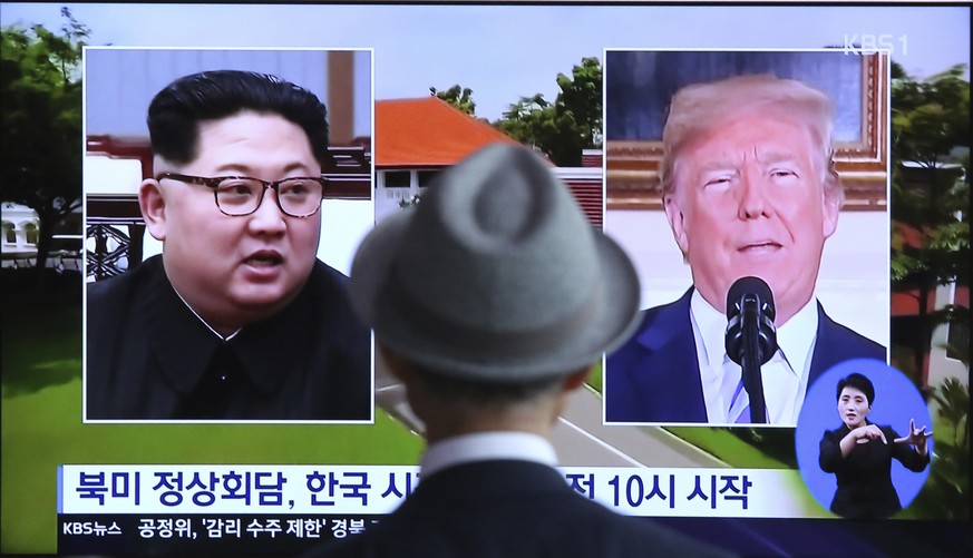 A man watches a TV screen showing file footage of U.S. President Donald Trump, right, and North Korean leader Kim Jong Un during a news program at the Seoul Railway Station in Seoul, South Korea, Mond ...