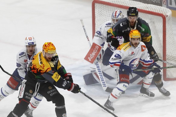 Zuerichs Christian Marti, Fribourgs Topscorer Daniel Brodin, Zuerichs Topscorer Garrett Roe, Fribourgs Samuel Walser und Zuerichs Torhueter Lukas Flueeler, von links, im Eishockey Meisterschaftsspiel  ...