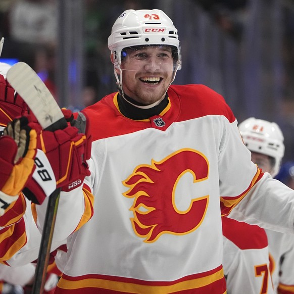 Calgary Flames right wing Adam Klapka is congratulated as he passes the team box after scoring the tying goal in the third period of an NHL hockey game against the Colorado Avalanche Monday, March 31, ...