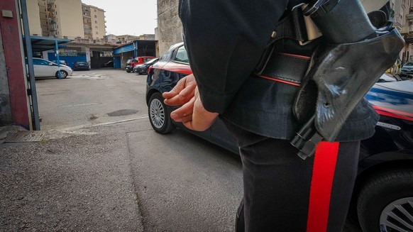 epa09146741 Carabinieri stand guard on the place where a man was killed following an alleged parking-space dispute in Torre Annunziata, Naples district, Italy, 20 April 2021. Maurizio Cerrato a 61-yea ...